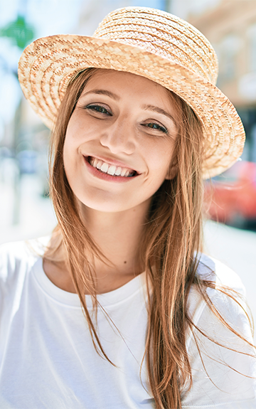  Junge Frau mit Sonnenhut auf der Straße 
